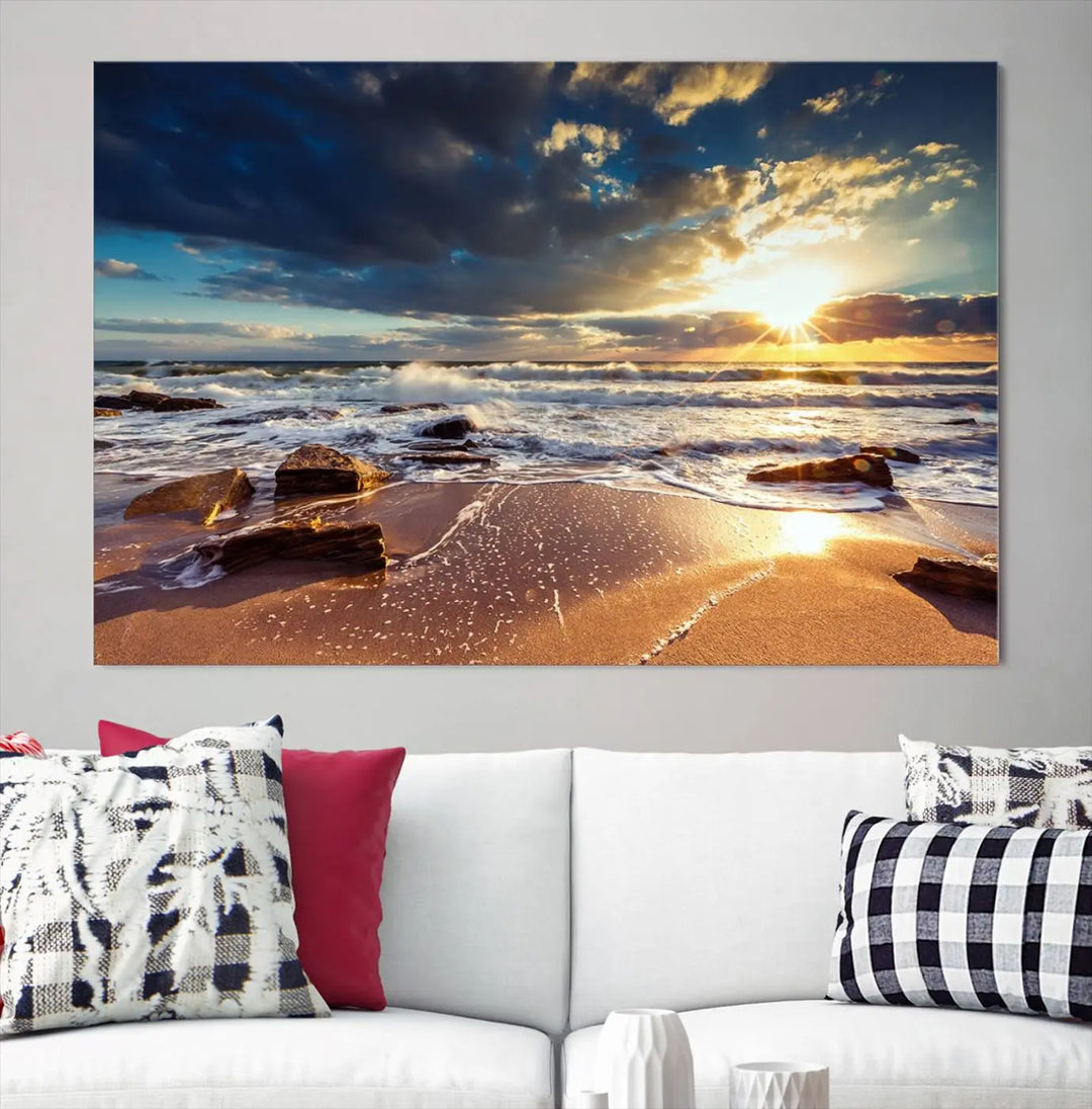 The cozy living room is enhanced by the Golden Hour Beach Sunset Canvas Triptych, featuring ocean waves and rocks.