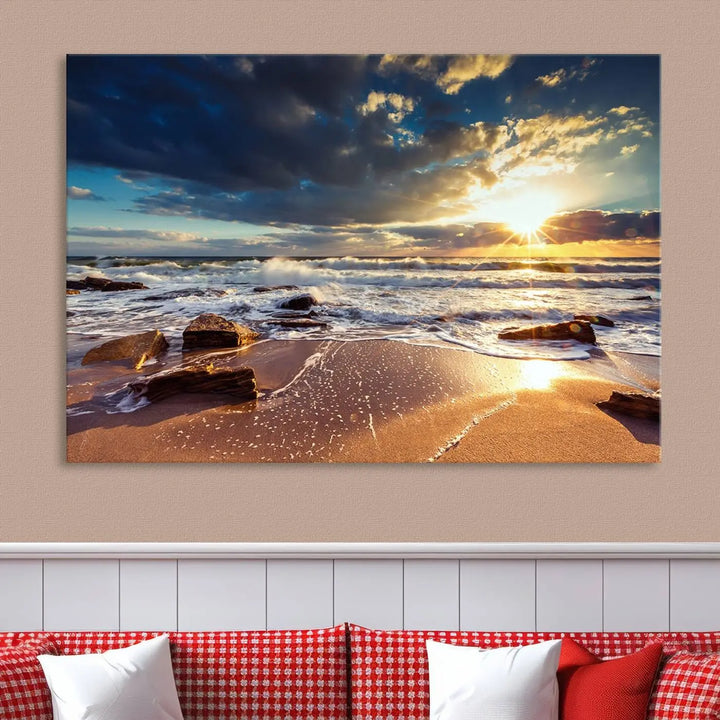 The cozy living room is enhanced by the Golden Hour Beach Sunset Canvas Triptych, featuring ocean waves and rocks.