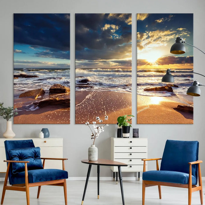 The cozy living room is enhanced by the Golden Hour Beach Sunset Canvas Triptych, featuring ocean waves and rocks.