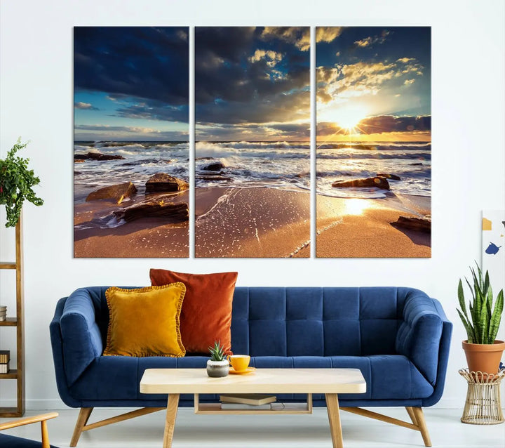 The cozy living room is enhanced by the Golden Hour Beach Sunset Canvas Triptych, featuring ocean waves and rocks.