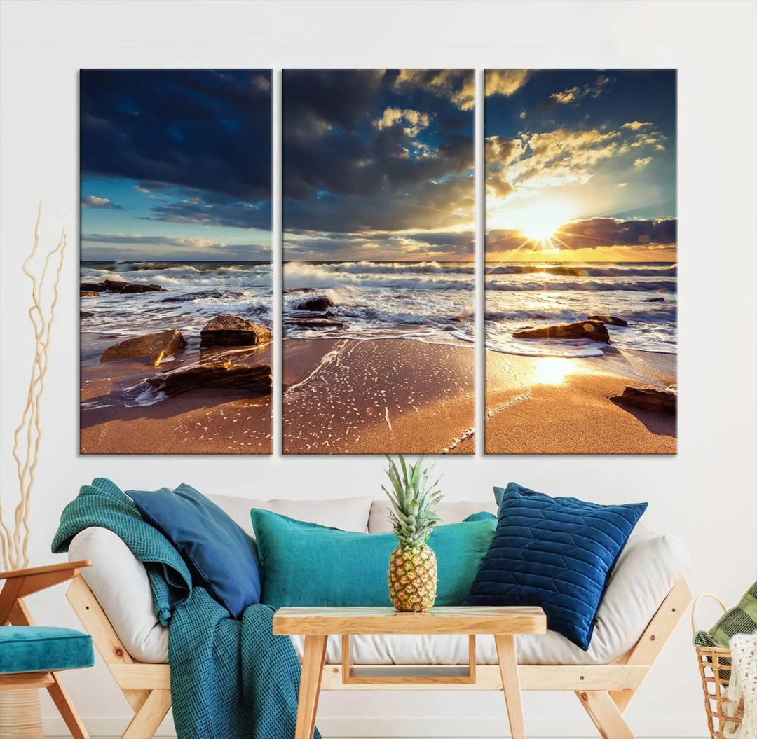 The cozy living room is enhanced by the Golden Hour Beach Sunset Canvas Triptych, featuring ocean waves and rocks.