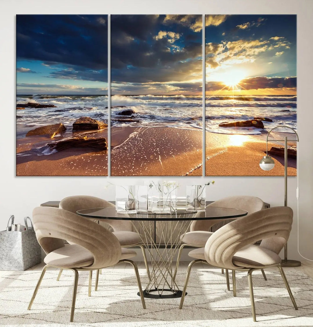 The cozy living room is enhanced by the Golden Hour Beach Sunset Canvas Triptych, featuring ocean waves and rocks.