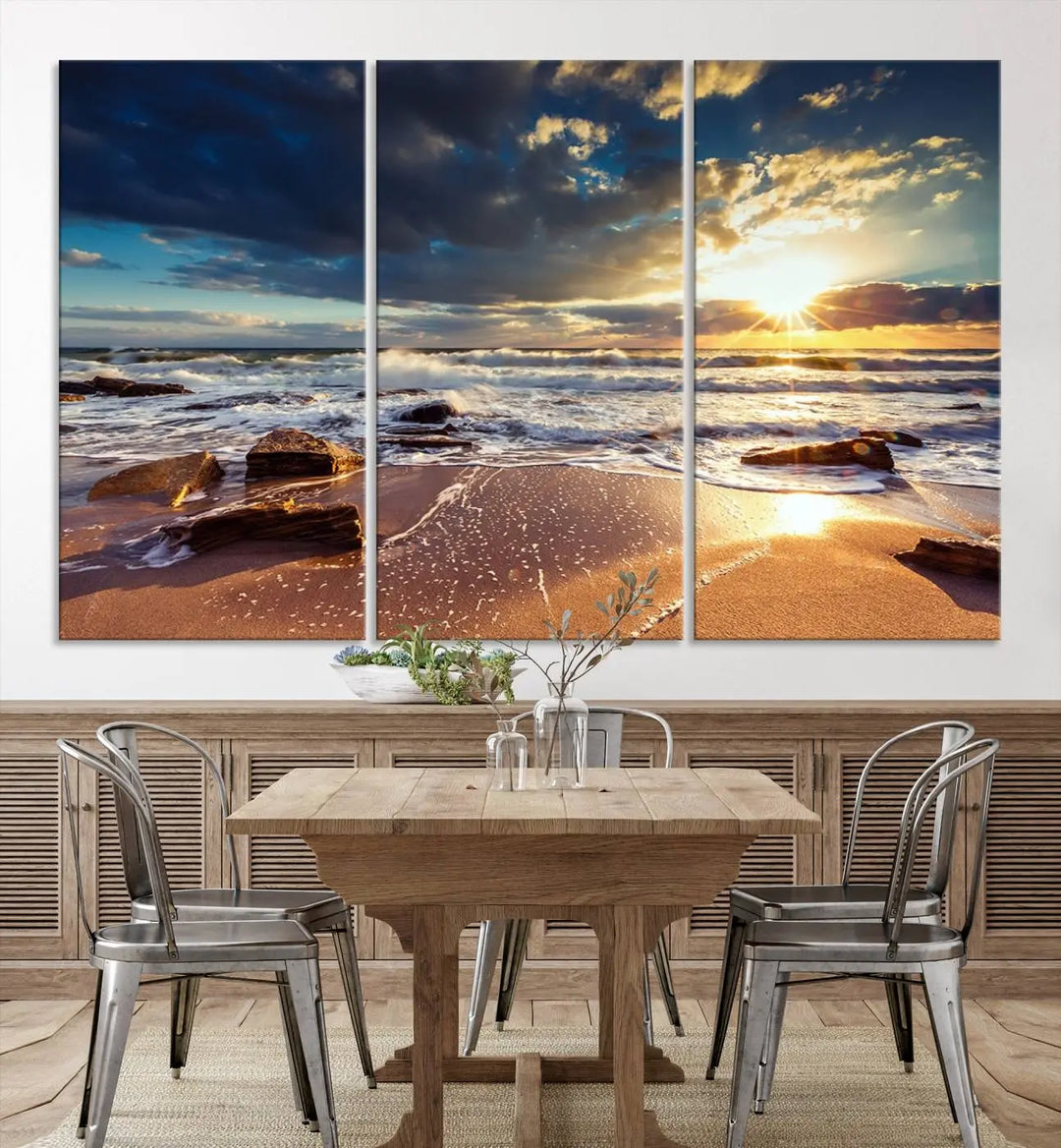 The cozy living room is enhanced by the Golden Hour Beach Sunset Canvas Triptych, featuring ocean waves and rocks.