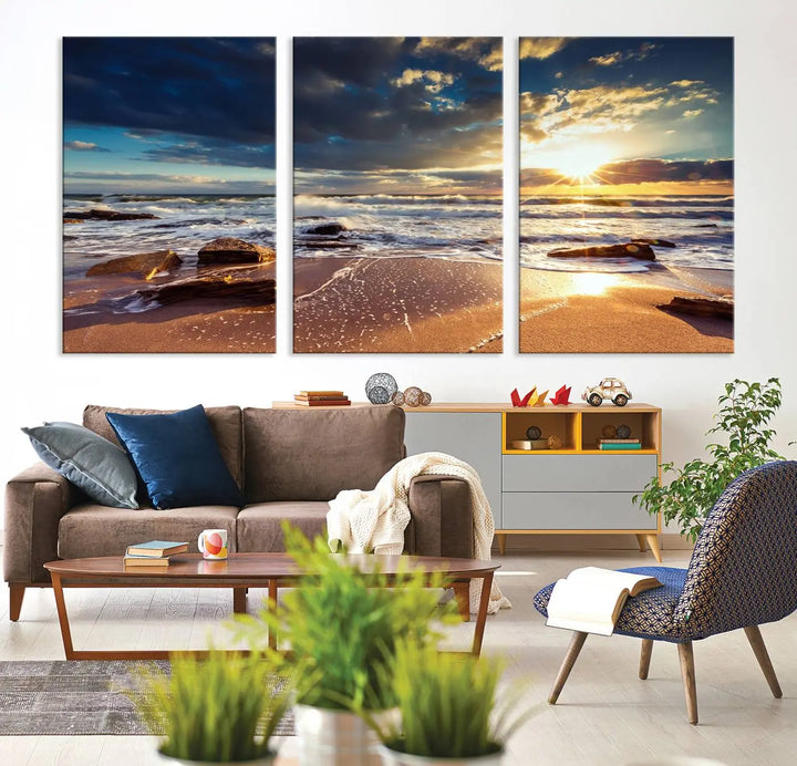 The cozy living room is enhanced by the Golden Hour Beach Sunset Canvas Triptych, featuring ocean waves and rocks.