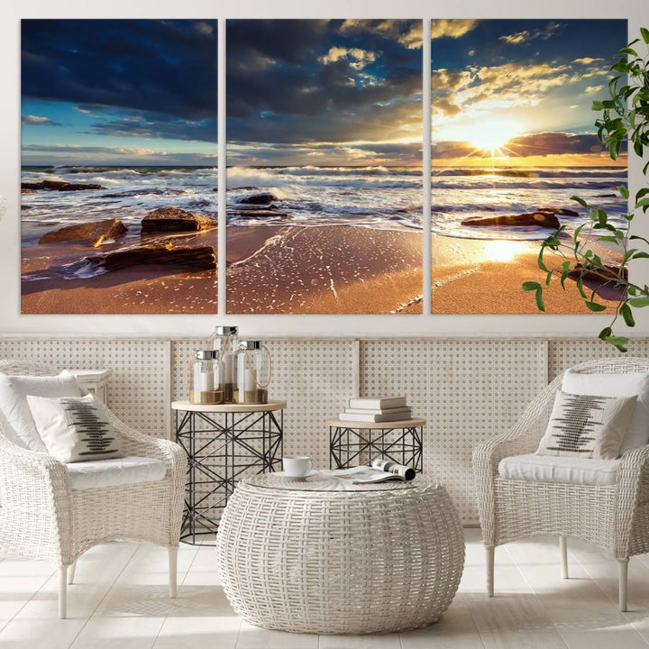 The cozy living room is enhanced by the Golden Hour Beach Sunset Canvas Triptych, featuring ocean waves and rocks.