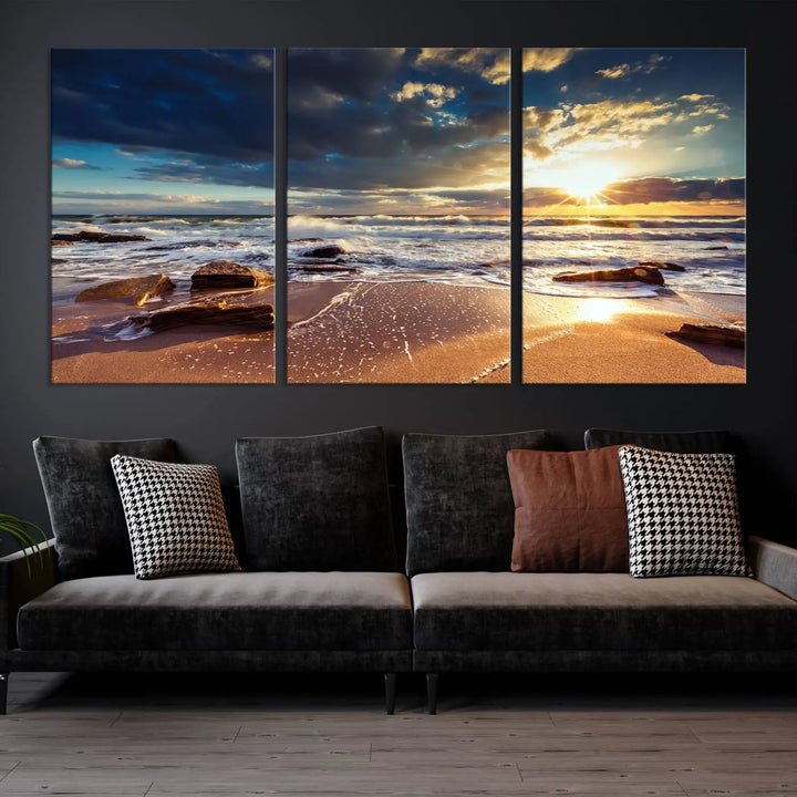 The cozy living room is enhanced by the Golden Hour Beach Sunset Canvas Triptych, featuring ocean waves and rocks.