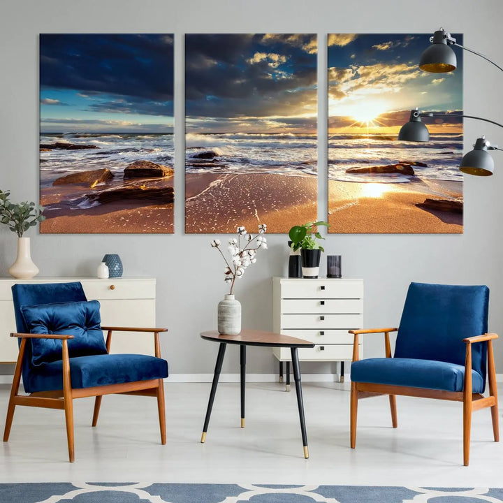 The cozy living room is enhanced by the Golden Hour Beach Sunset Canvas Triptych, featuring ocean waves and rocks.