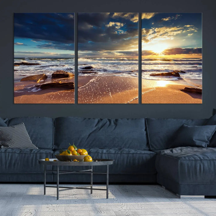 The cozy living room is enhanced by the Golden Hour Beach Sunset Canvas Triptych, featuring ocean waves and rocks.