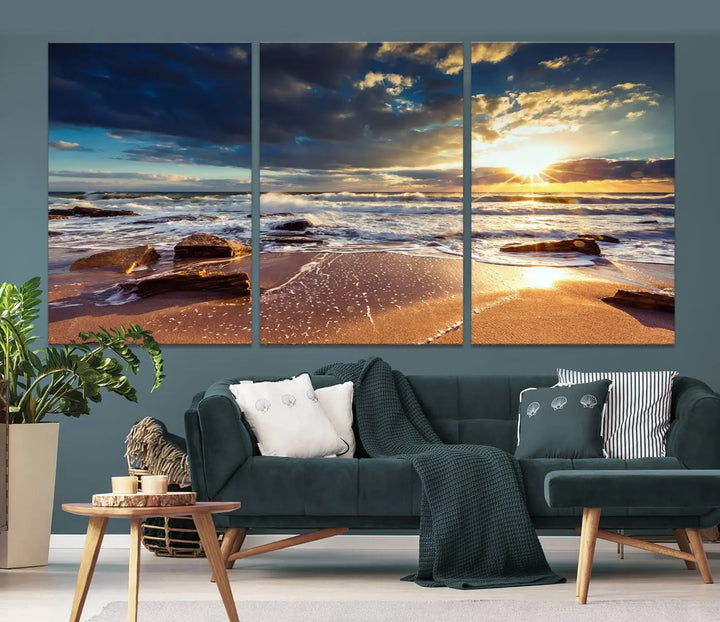 The cozy living room is enhanced by the Golden Hour Beach Sunset Canvas Triptych, featuring ocean waves and rocks.