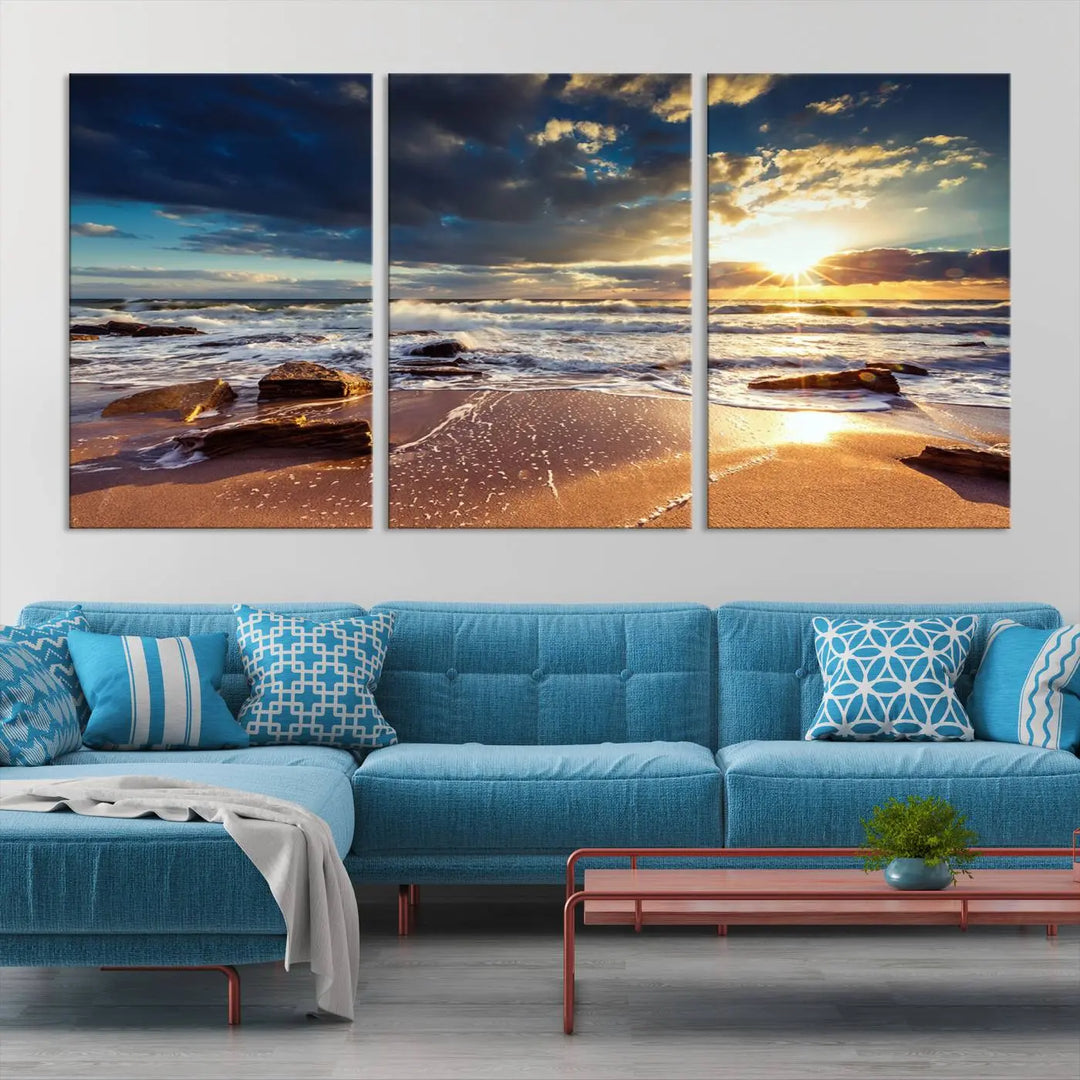 The cozy living room is enhanced by the Golden Hour Beach Sunset Canvas Triptych, featuring ocean waves and rocks.