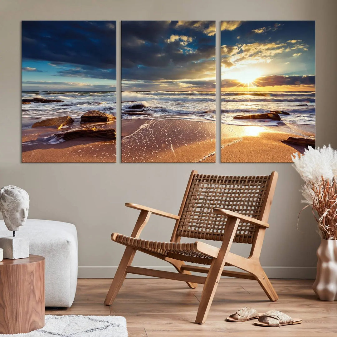 The cozy living room is enhanced by the Golden Hour Beach Sunset Canvas Triptych, featuring ocean waves and rocks.