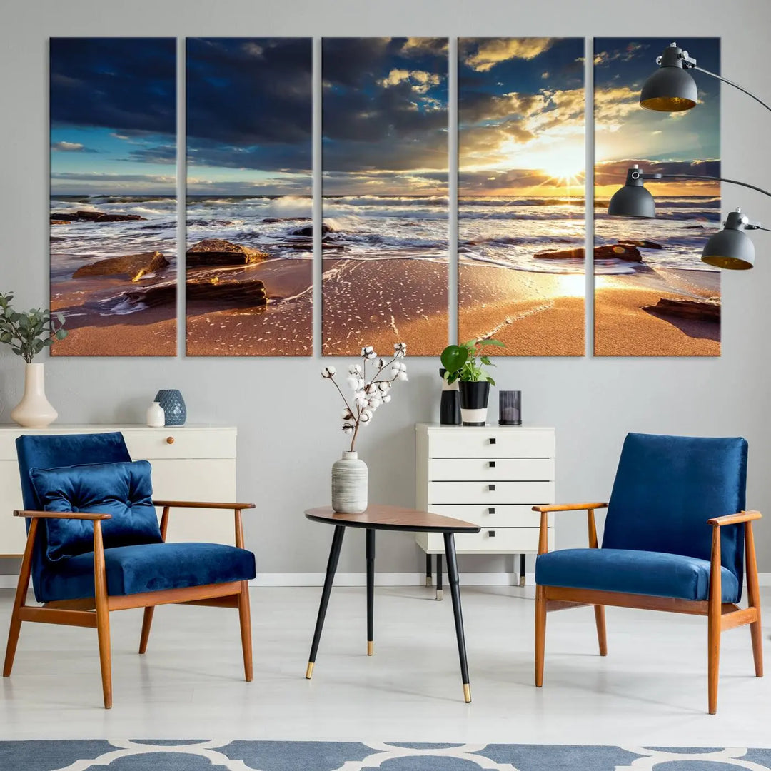 The cozy living room is enhanced by the Golden Hour Beach Sunset Canvas Triptych, featuring ocean waves and rocks.