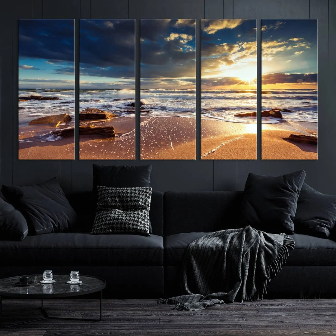 The cozy living room is enhanced by the Golden Hour Beach Sunset Canvas Triptych, featuring ocean waves and rocks.