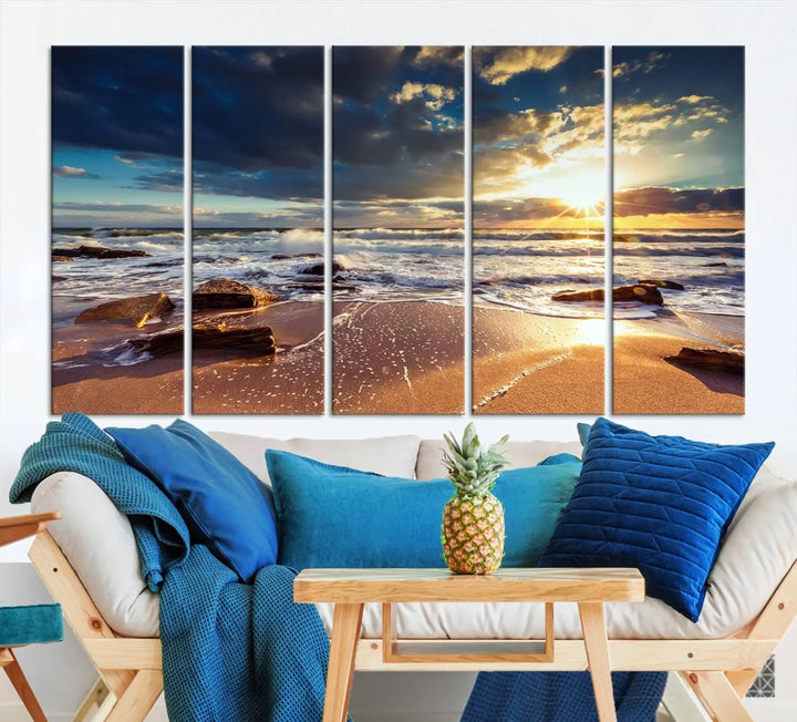 The cozy living room is enhanced by the Golden Hour Beach Sunset Canvas Triptych, featuring ocean waves and rocks.