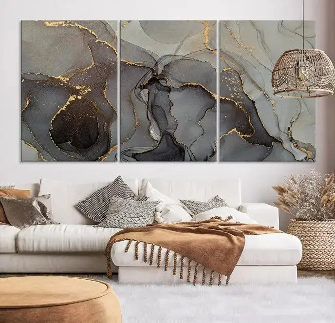 The Gray Marble Fluid Effect Wall Art Abstract Canvas Wall Art Print is a museum-quality canvas featuring triptych abstract art with swirling gray and gold patterns. Complete with a UV-protective coating, this piece of artwork arrives ready to hang, effortlessly elevating your living space.