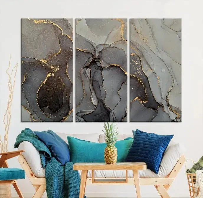 The Gray Marble Fluid Effect Wall Art Abstract Canvas Wall Art Print is a museum-quality canvas featuring triptych abstract art with swirling gray and gold patterns. Complete with a UV-protective coating, this piece of artwork arrives ready to hang, effortlessly elevating your living space.