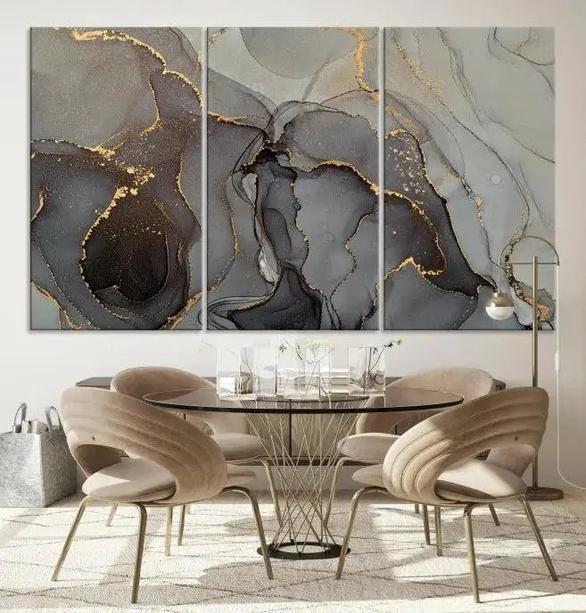 The Gray Marble Fluid Effect Wall Art Abstract Canvas Wall Art Print is a museum-quality canvas featuring triptych abstract art with swirling gray and gold patterns. Complete with a UV-protective coating, this piece of artwork arrives ready to hang, effortlessly elevating your living space.