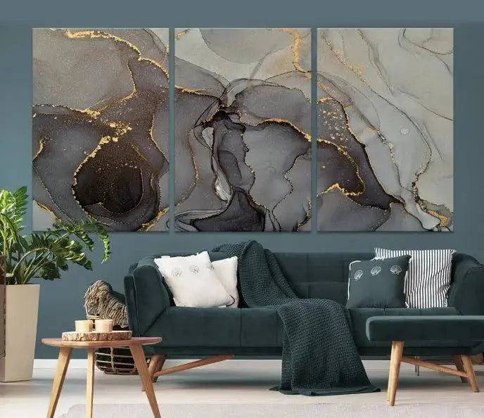 The Gray Marble Fluid Effect Wall Art Abstract Canvas Wall Art Print is a museum-quality canvas featuring triptych abstract art with swirling gray and gold patterns. Complete with a UV-protective coating, this piece of artwork arrives ready to hang, effortlessly elevating your living space.