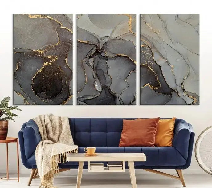 The Gray Marble Fluid Effect Wall Art Abstract Canvas Wall Art Print is a museum-quality canvas featuring triptych abstract art with swirling gray and gold patterns. Complete with a UV-protective coating, this piece of artwork arrives ready to hang, effortlessly elevating your living space.