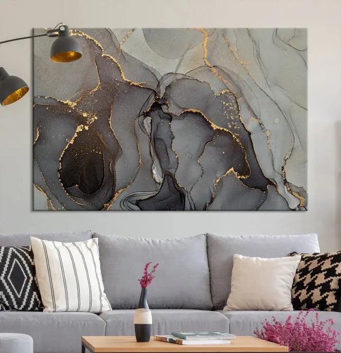 The Gray Marble Fluid Effect Wall Art Abstract Canvas Wall Art Print is a museum-quality canvas featuring triptych abstract art with swirling gray and gold patterns. Complete with a UV-protective coating, this piece of artwork arrives ready to hang, effortlessly elevating your living space.