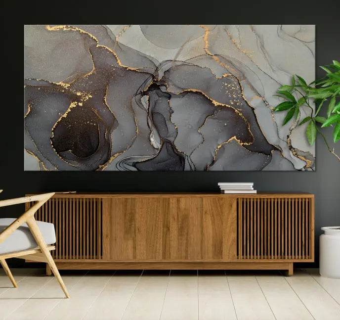 The Gray Marble Fluid Effect Wall Art Abstract Canvas Wall Art Print is a museum-quality canvas featuring triptych abstract art with swirling gray and gold patterns. Complete with a UV-protective coating, this piece of artwork arrives ready to hang, effortlessly elevating your living space.