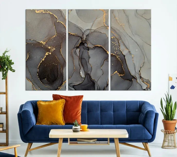 The Gray Marble Fluid Effect Wall Art Abstract Canvas Wall Art Print is a museum-quality canvas featuring triptych abstract art with swirling gray and gold patterns. Complete with a UV-protective coating, this piece of artwork arrives ready to hang, effortlessly elevating your living space.