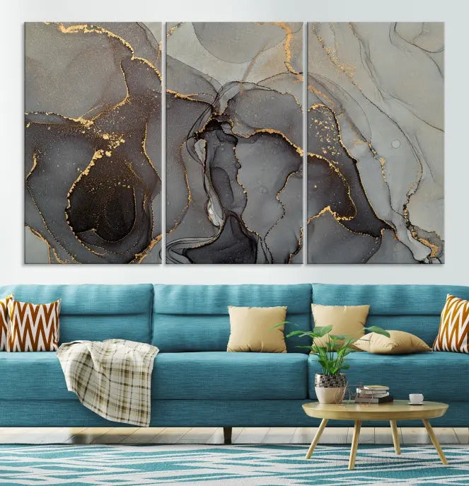 The Gray Marble Fluid Effect Wall Art Abstract Canvas Wall Art Print is a museum-quality canvas featuring triptych abstract art with swirling gray and gold patterns. Complete with a UV-protective coating, this piece of artwork arrives ready to hang, effortlessly elevating your living space.