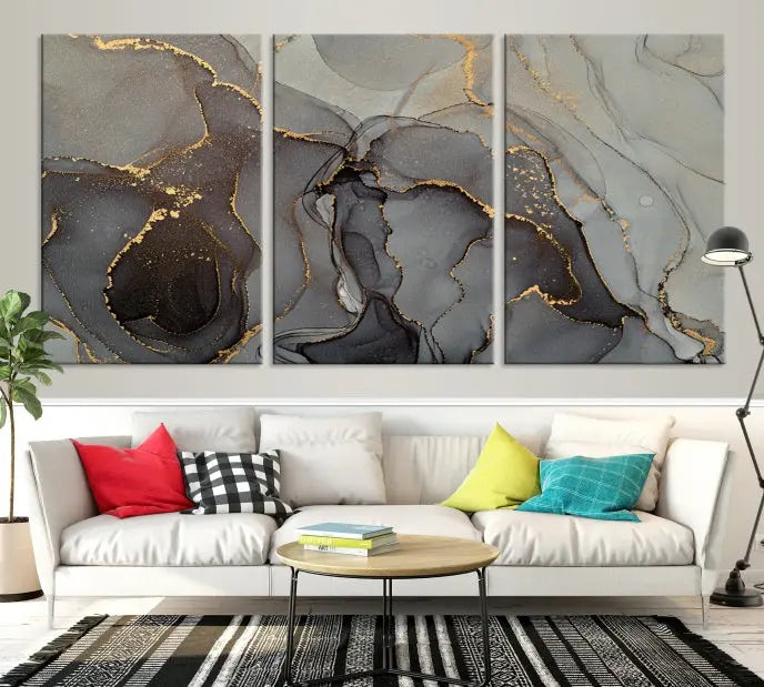 The Gray Marble Fluid Effect Wall Art Abstract Canvas Wall Art Print is a museum-quality canvas featuring triptych abstract art with swirling gray and gold patterns. Complete with a UV-protective coating, this piece of artwork arrives ready to hang, effortlessly elevating your living space.