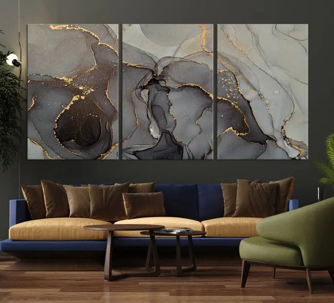 The Gray Marble Fluid Effect Wall Art Abstract Canvas Wall Art Print is a museum-quality canvas featuring triptych abstract art with swirling gray and gold patterns. Complete with a UV-protective coating, this piece of artwork arrives ready to hang, effortlessly elevating your living space.