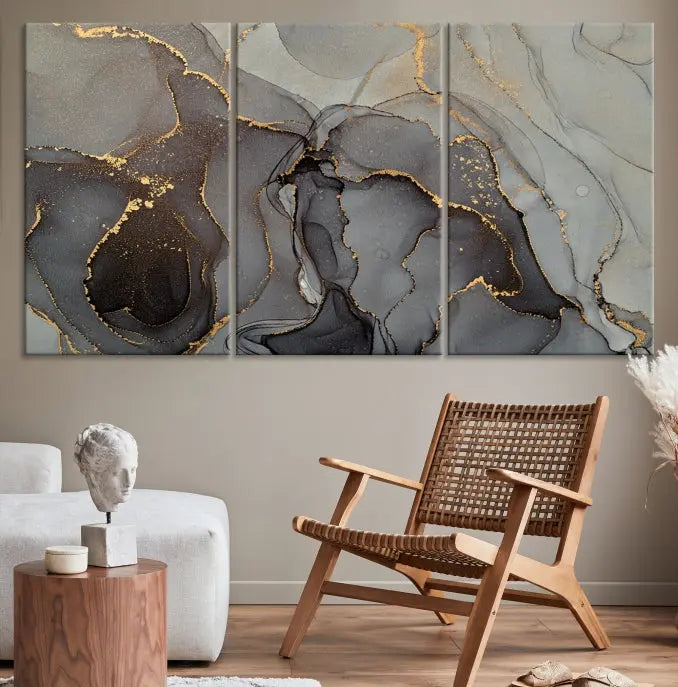 The Gray Marble Fluid Effect Wall Art Abstract Canvas Wall Art Print is a museum-quality canvas featuring triptych abstract art with swirling gray and gold patterns. Complete with a UV-protective coating, this piece of artwork arrives ready to hang, effortlessly elevating your living space.