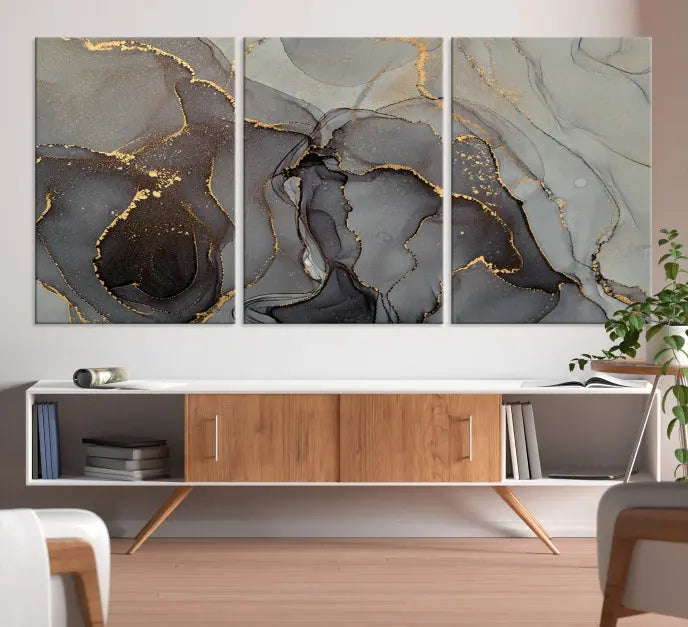 The Gray Marble Fluid Effect Wall Art Abstract Canvas Wall Art Print is a museum-quality canvas featuring triptych abstract art with swirling gray and gold patterns. Complete with a UV-protective coating, this piece of artwork arrives ready to hang, effortlessly elevating your living space.