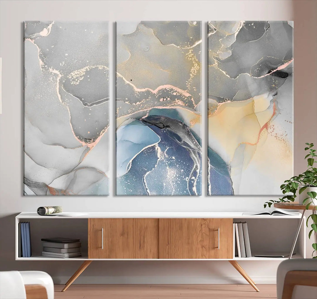 The Gray Marble Fluid Effect Wall Art Abstract Canvas Wall Art Print features elegant gold, blue, and gray hues. Crafted on museum-quality canvas, it includes a UV-protective coating for enduring vibrance. Enjoy the added benefit of free shipping.