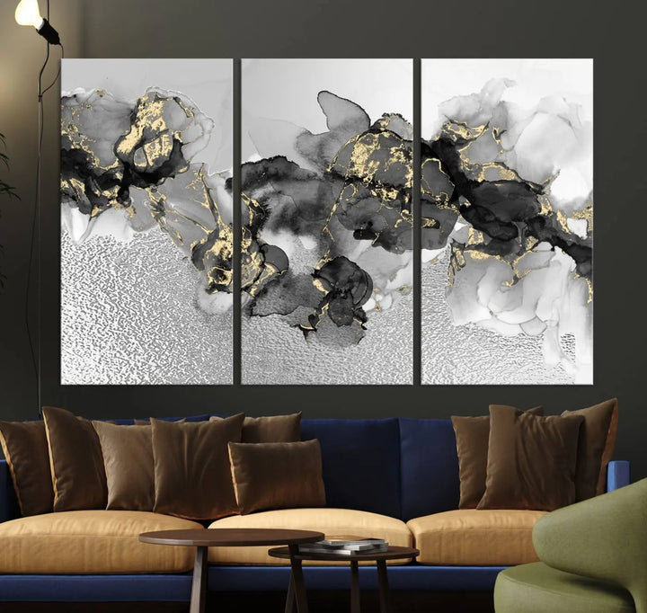 The Gray Marble Fluid Effect Wall Art Abstract Canvas Print, featuring black, white, and gold textured patterns, is crafted on museum-quality canvases and finished with a UV-protective coating. This piece adds sophistication to any space.