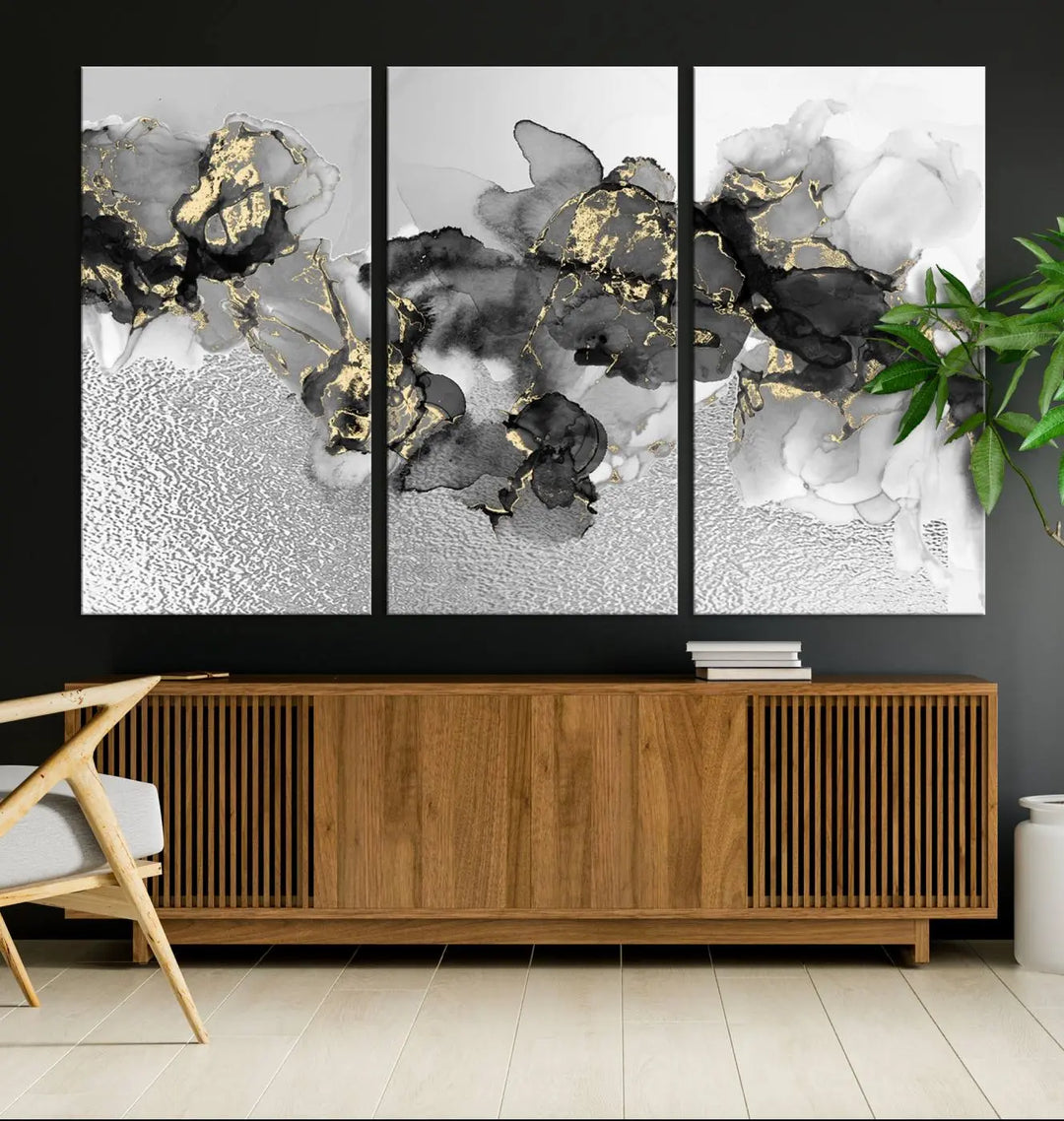 The Gray Marble Fluid Effect Wall Art Abstract Canvas Print, featuring black, white, and gold textured patterns, is crafted on museum-quality canvases and finished with a UV-protective coating. This piece adds sophistication to any space.