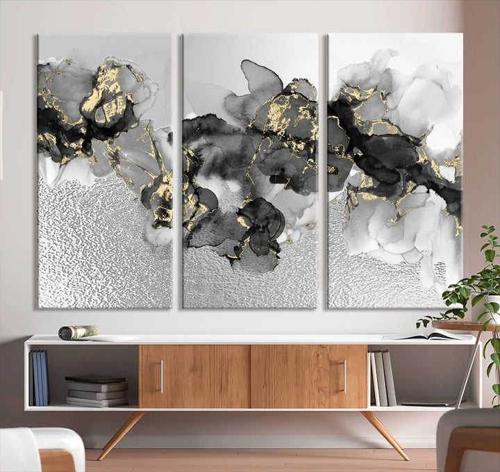 The Gray Marble Fluid Effect Wall Art Abstract Canvas Print, featuring black, white, and gold textured patterns, is crafted on museum-quality canvases and finished with a UV-protective coating. This piece adds sophistication to any space.