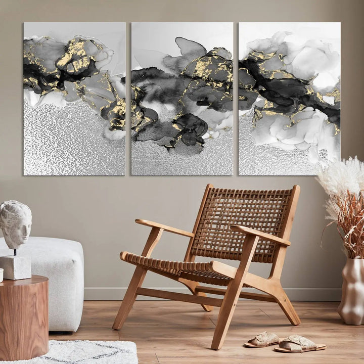 The Gray Marble Fluid Effect Wall Art Abstract Canvas Print, featuring black, white, and gold textured patterns, is crafted on museum-quality canvases and finished with a UV-protective coating. This piece adds sophistication to any space.