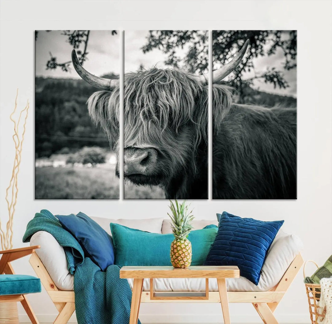 The stylish living room showcases the "Highland Cow Wall Art Canvas Print Scottish Cattle Canvas Art" displayed as a triptych on the wall. This artwork is gallery wrapped on museum-quality canvas with a UV-protective coating for lasting elegance.