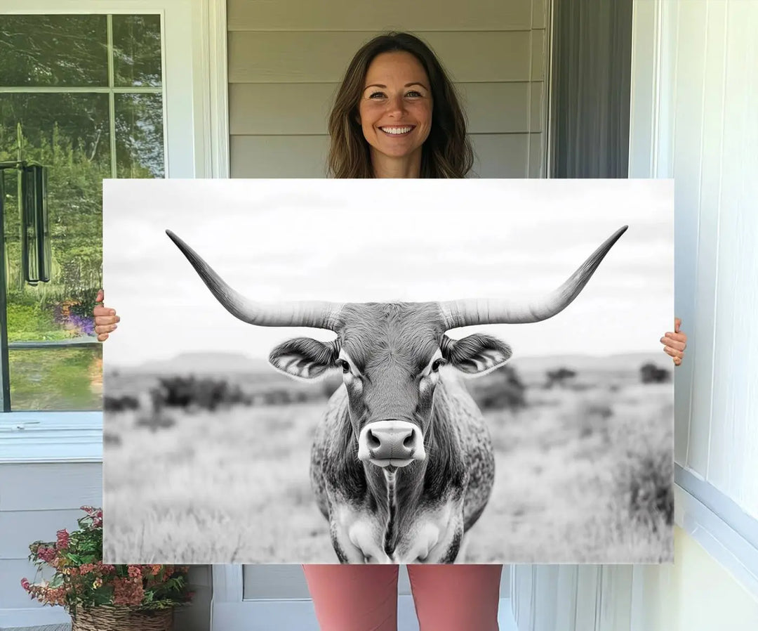 The "Highland Cow Wall Art Print," featuring a black and white depiction of a Texas Western Longhorn, elegantly adorns the wall. This Southwestern animal artwork for home is crafted as premium canvas wall art, ensuring a gallery-quality finish.