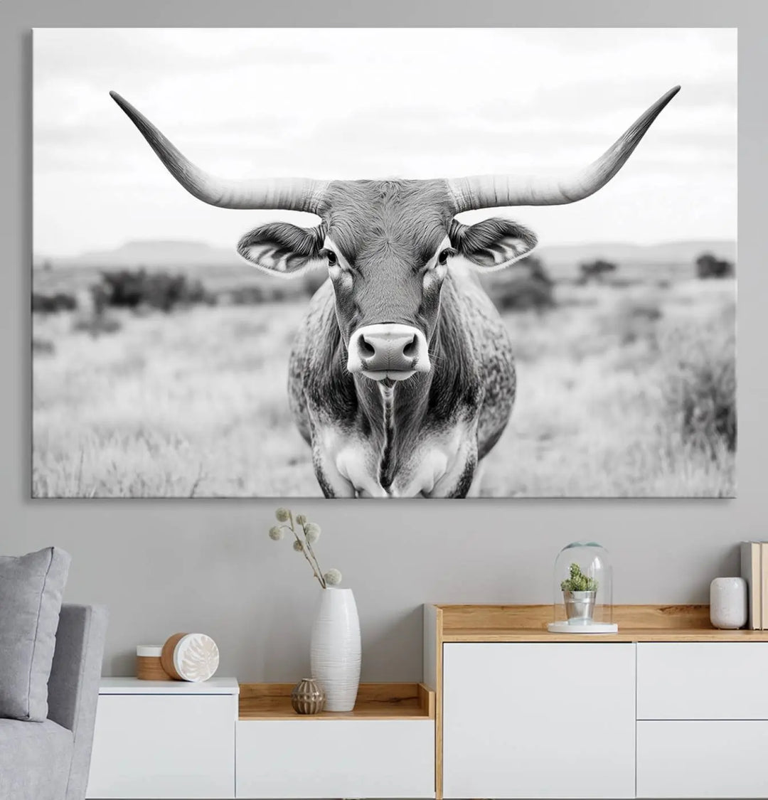 The "Highland Cow Wall Art Print," featuring a black and white depiction of a Texas Western Longhorn, elegantly adorns the wall. This Southwestern animal artwork for home is crafted as premium canvas wall art, ensuring a gallery-quality finish.