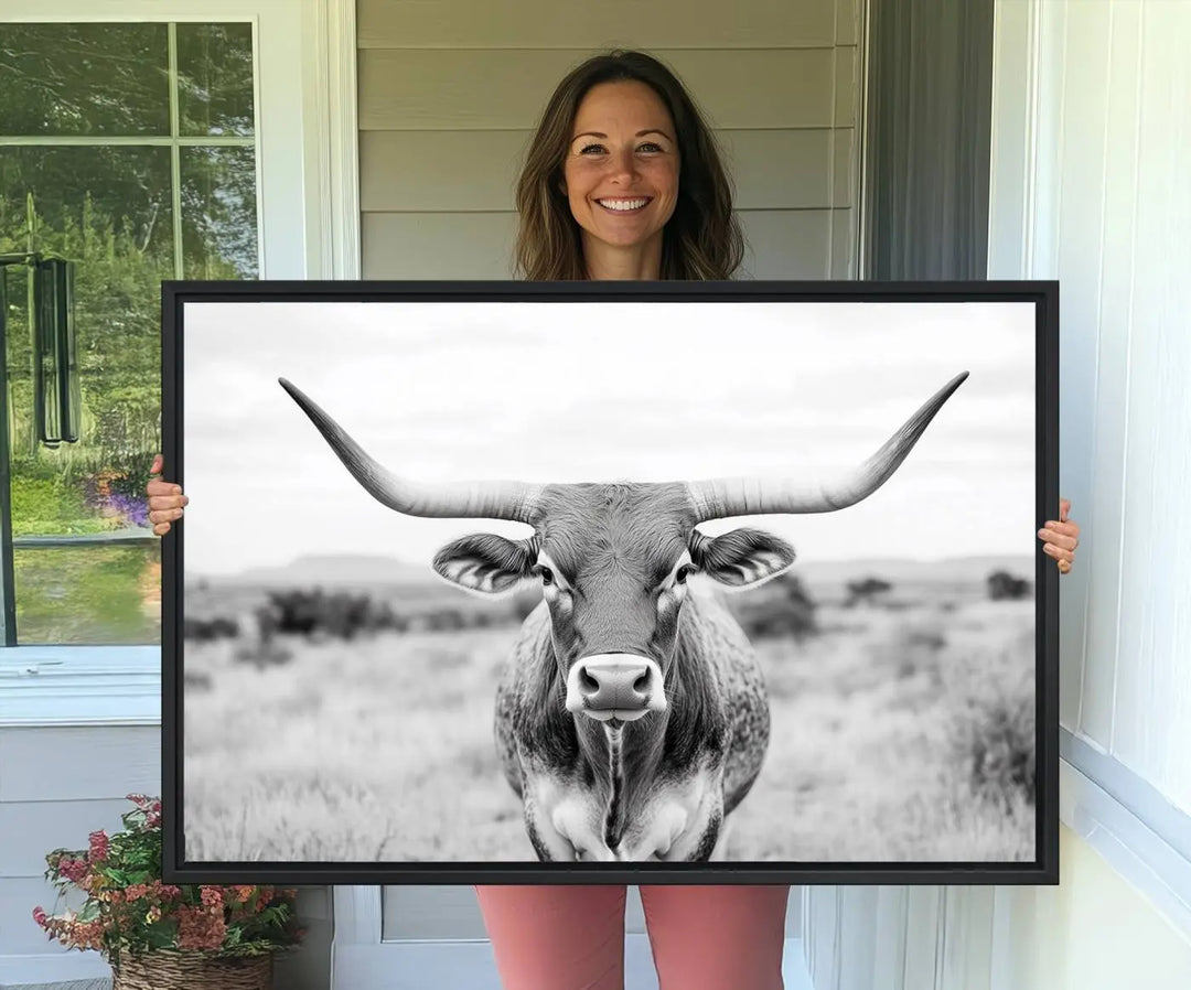 The "Highland Cow Wall Art Print," featuring a black and white depiction of a Texas Western Longhorn, elegantly adorns the wall. This Southwestern animal artwork for home is crafted as premium canvas wall art, ensuring a gallery-quality finish.