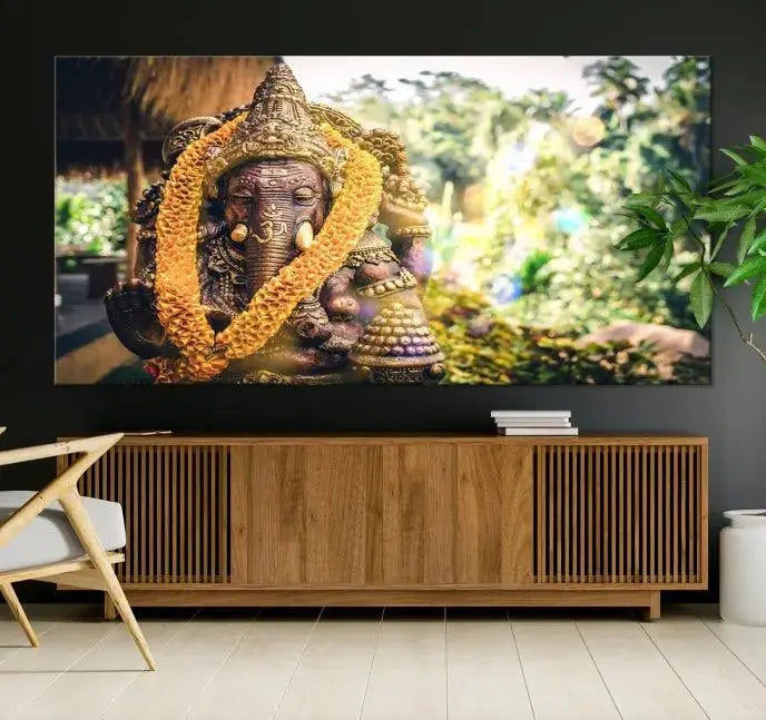 A set of three panels depicting the Hindu deity Lord Ganesha, embellished with a yellow garland, gracefully decorates a wall. This gallery-wrapped artwork, known as the Hinduism Statue Wall Art Canvas Print, is meticulously crafted on museum-quality canvas for an exquisite finish.