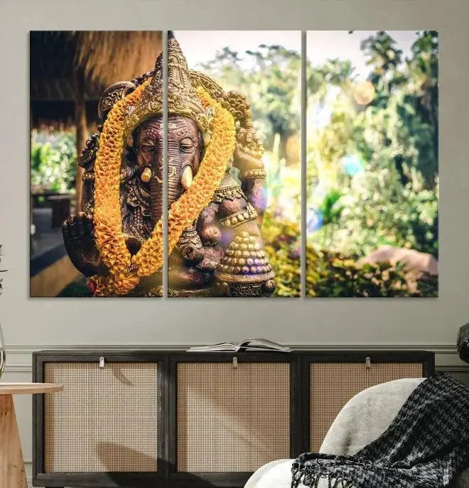 A set of three panels depicting the Hindu deity Lord Ganesha, embellished with a yellow garland, gracefully decorates a wall. This gallery-wrapped artwork, known as the Hinduism Statue Wall Art Canvas Print, is meticulously crafted on museum-quality canvas for an exquisite finish.