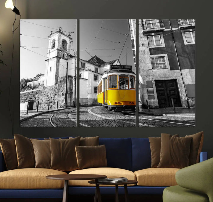 The Iconic Yellow Lisbon Tram Canvas Wall Art Print showcases a yellow tram navigating through a monochrome street scene, with a historic building in the background, exquisitely captured on museum-quality canvas.