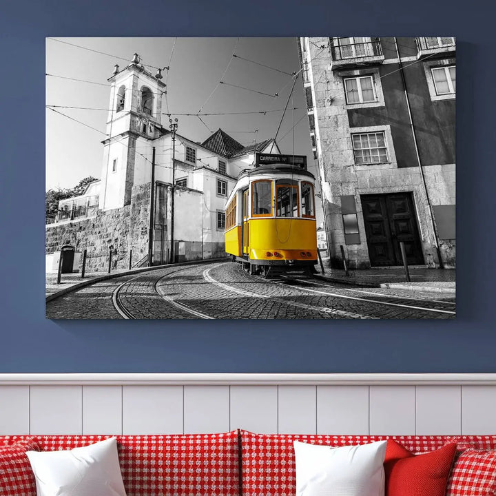 The Iconic Yellow Lisbon Tram Canvas Wall Art Print showcases a yellow tram navigating through a monochrome street scene, with a historic building in the background, exquisitely captured on museum-quality canvas.