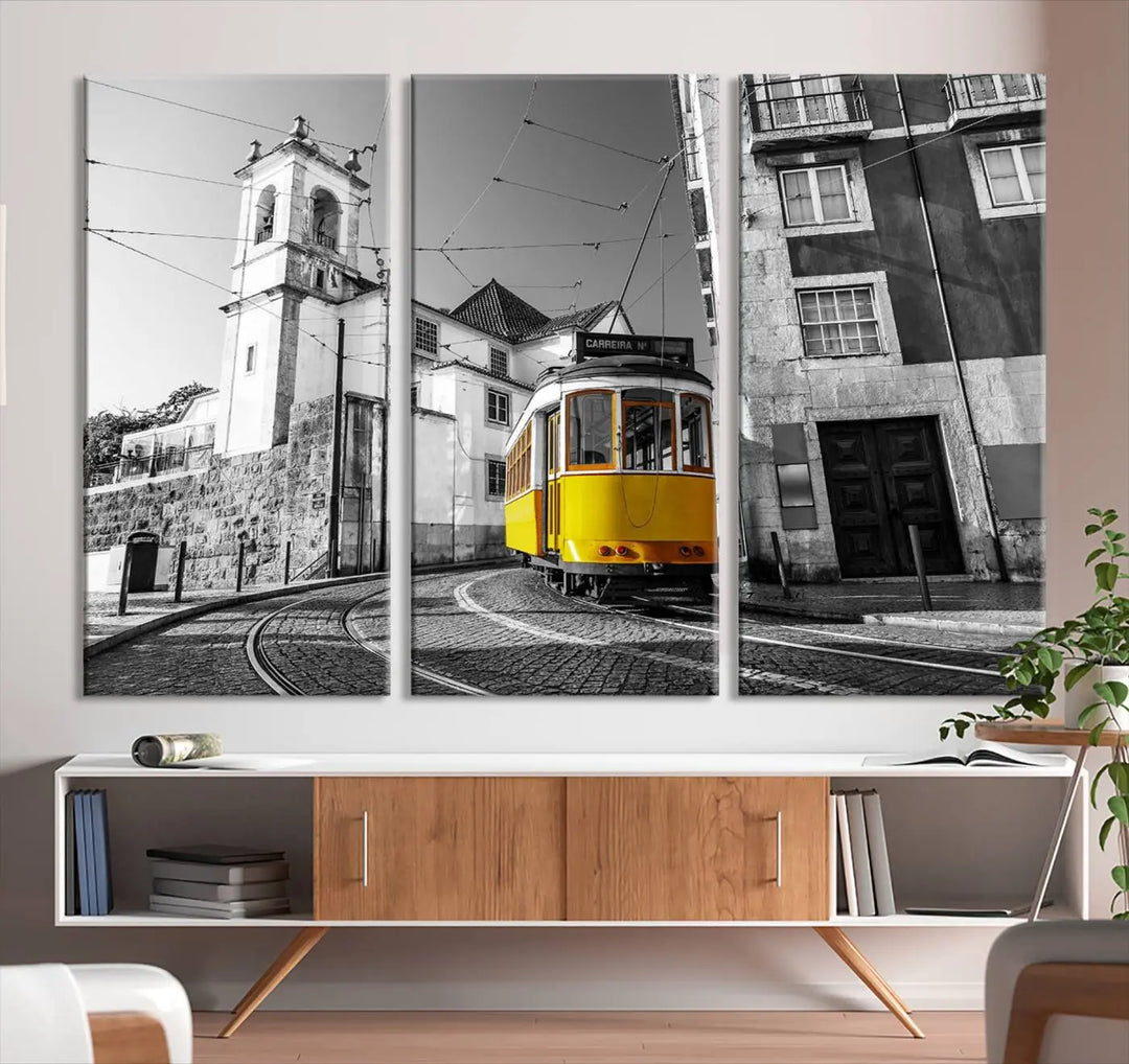 The Iconic Yellow Lisbon Tram Canvas Wall Art Print showcases a yellow tram navigating through a monochrome street scene, with a historic building in the background, exquisitely captured on museum-quality canvas.