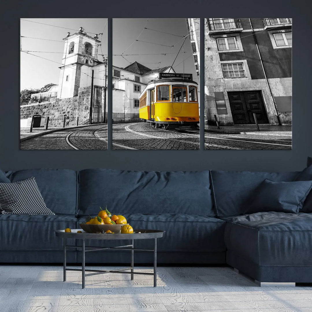 The Iconic Yellow Lisbon Tram Canvas Wall Art Print showcases a yellow tram navigating through a monochrome street scene, with a historic building in the background, exquisitely captured on museum-quality canvas.