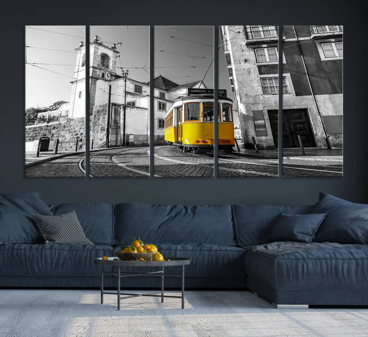 The Iconic Yellow Lisbon Tram Canvas Wall Art Print showcases a yellow tram navigating through a monochrome street scene, with a historic building in the background, exquisitely captured on museum-quality canvas.