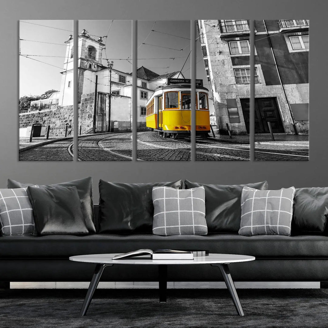 The Iconic Yellow Lisbon Tram Canvas Wall Art Print showcases a yellow tram navigating through a monochrome street scene, with a historic building in the background, exquisitely captured on museum-quality canvas.