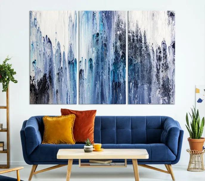 The minimalist room is adorned with the Ink Abstract Wall Art Canvas Print, featuring a museum-quality triptych in blue and white elegantly displayed. Rendered on UV-protective canvas for lasting vibrancy.