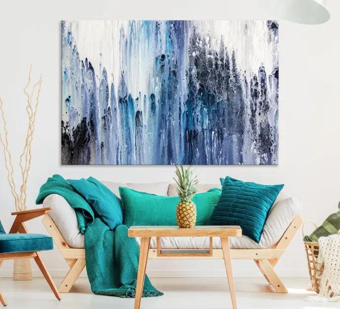 The minimalist room is adorned with the Ink Abstract Wall Art Canvas Print, featuring a museum-quality triptych in blue and white elegantly displayed. Rendered on UV-protective canvas for lasting vibrancy.